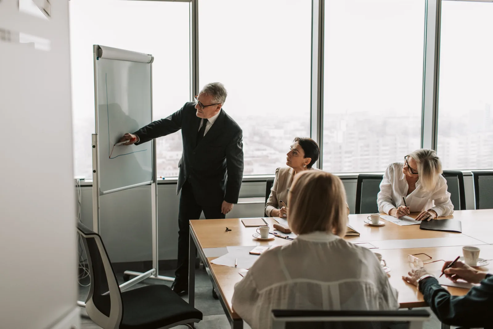 Vertriebsleiter erklärt seinem Team am Flipchart eine Entwicklung
